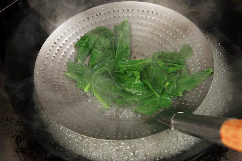 起鍋開大火，加入適當開水，水滾後放入綠色蔬菜燙熟，取出瀝乾切碎備用。