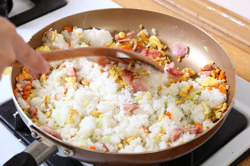 加入白飯，轉中小火，拌炒至米飯散開，呈現粒粒分明狀；加入鹽、醬油、胡椒粉調味，最後放入青蒜末拌炒數下即可起鍋。