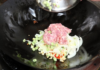 轉中火，放入洋蔥、絞肉、四季豆、玉米筍快炒15秒，放入2匙清水炒均勻。