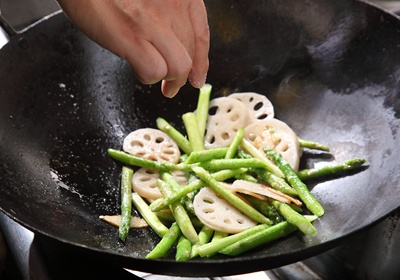 加蘆筍段、蓮藕片、糖、鹽、胡椒粉拌炒，可加入少許水，會讓蔬菜的顏色較鮮綠，也會加速食材熟化。