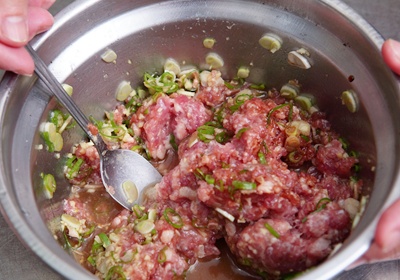 豬絞肉加入蔥末、薑末，並倒入許水、鹽、醬油及白胡椒粉少許，與豬絞肉攪拌均勻。