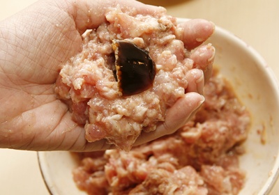 在肉團中央以指腹挖一個圓洞，再取1湯匙大小的咖啡凍填入，再用絞肉將咖啡凍包覆於其中。