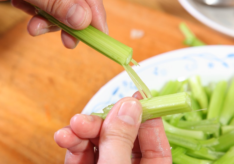 挑除芹菜管葉子，再將芹菜管表面纖維剔除。