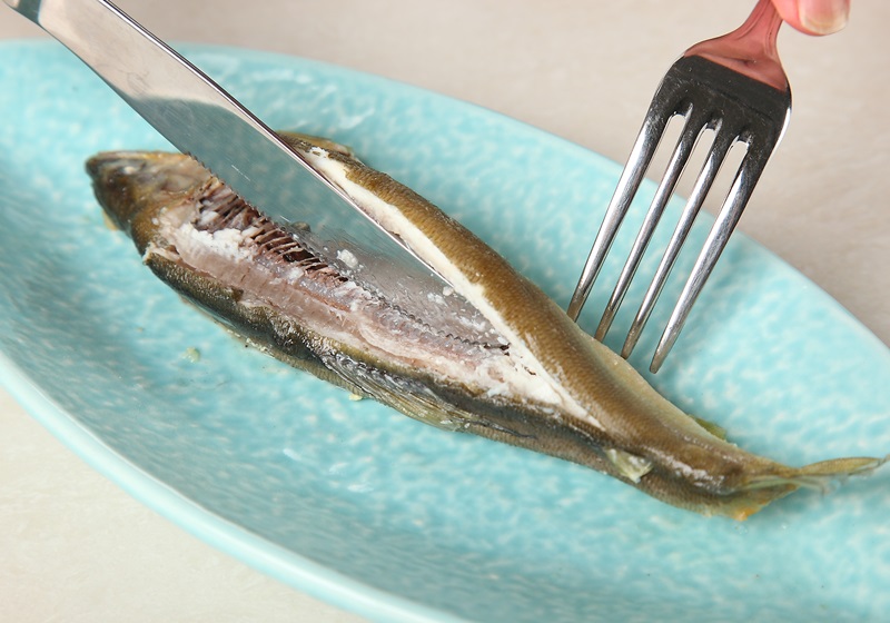 再將剖半的魚身翻起。