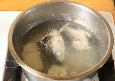 虱目魚頭、尾及骨洗淨，放入鍋中，加入約4碗水，先以大火煮開，湯滾時轉小火慢慢熬煮湯頭，約需40分鐘∼1小時，撈出魚骨、留湯汁備用。