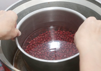 將洗好的紅豆放入鍋內，加水淹過2cm，煮滾以後將水倒掉，再加水淹過紅豆1cm並放入電鍋，外鍋加1杯水燜煮。