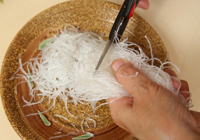 冬粉先泡水約10分鐘，待軟後以剪刀剪成小條狀。木耳切小丁。蝦子洗淨後剝殼去頭，並切成小段備用。