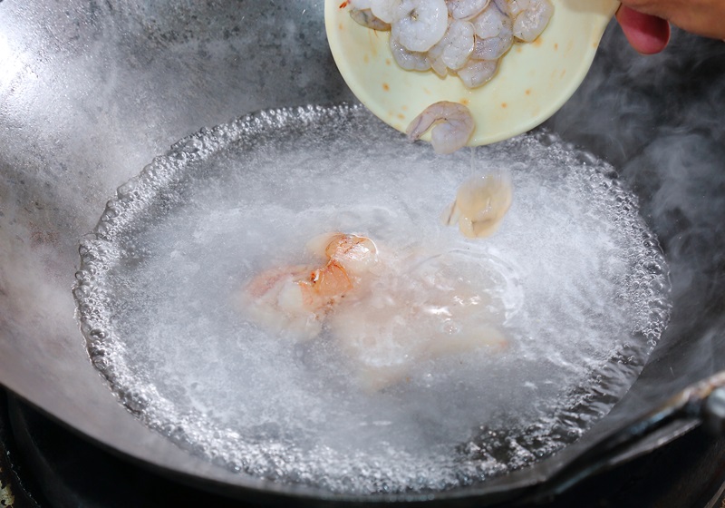 起一鍋滾水，加入花枝、魷魚、魚板、蝦仁、蟹腿肉汆燙，待水再次煮滾、撈起；置於水龍頭下沖洗、瀝乾備用。