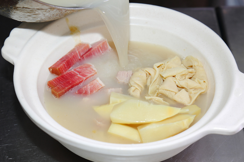 加入雞高湯與鹽,開小火熬煮半小時,最後加入青江菜和蒜苗絲點綴即完成。