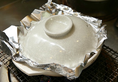 如圖，於食材上覆蓋一層錫箔增加受熱，蓋上鍋蓋，以小火煮約13分鐘、關火再燜約12分鐘，打開鍋蓋、將食材拌勻。