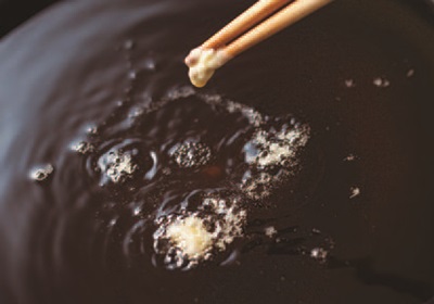 把油炸的油加熱到中溫：開中火把油炸的油加熱到 170～180℃。用料理筷沾麵衣，滴在油鍋裡，如果沉到中間立刻浮上來的話，就是中溫的標準。