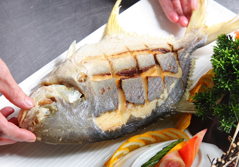 在魚身撒上白胡椒鹽,均勻淋上梅林辣醬油調味。