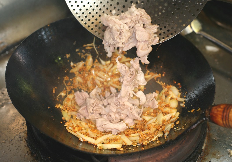 待豆酥呈現金黃微焦、香氣四溢時，加入白肉與豆酥一起拌炒，並加入糖、豆瓣醬等調味。