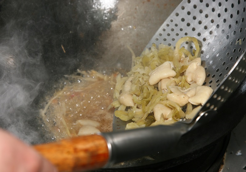 接著加入汆燙好的大腸、酸菜翻炒，起鍋前再以太白粉水勾芡即完成。