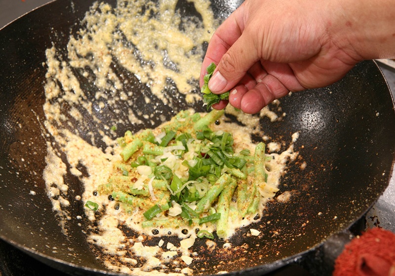 將蔥段、蒜末及雞粉放入鍋中，繼續保持中火，與食材拌炒5秒起鍋即完成。