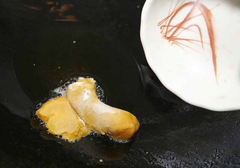 將多餘的油倒出，利用原鍋的餘油轉小火繼續加熱，放入鹹蛋黃炒開，接著放入辣椒片。