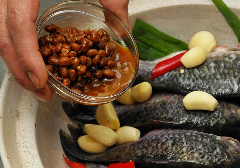 將鯽魚，辣椒段、黃豆醬、蒜頭一起放進鍋中。