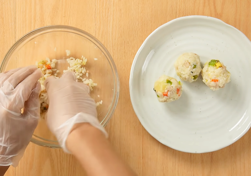 【酥炸飯球】將炒飯與起司粉拌勻，用手壓成球狀。