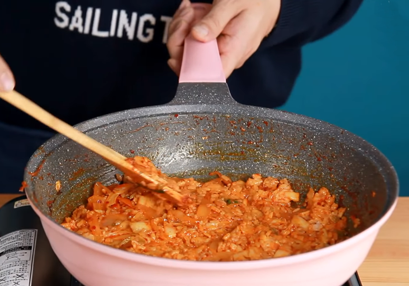 將炒好的飯鋪平在鍋中。