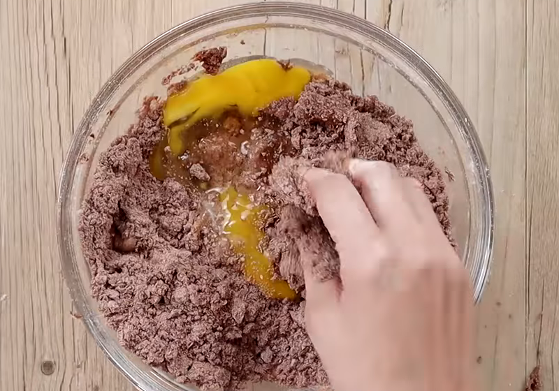 【塔皮】倒入牛奶抓勻後，分次下蛋液搓揉均勻成糰，再用保鮮膜包起，冷藏1小時。