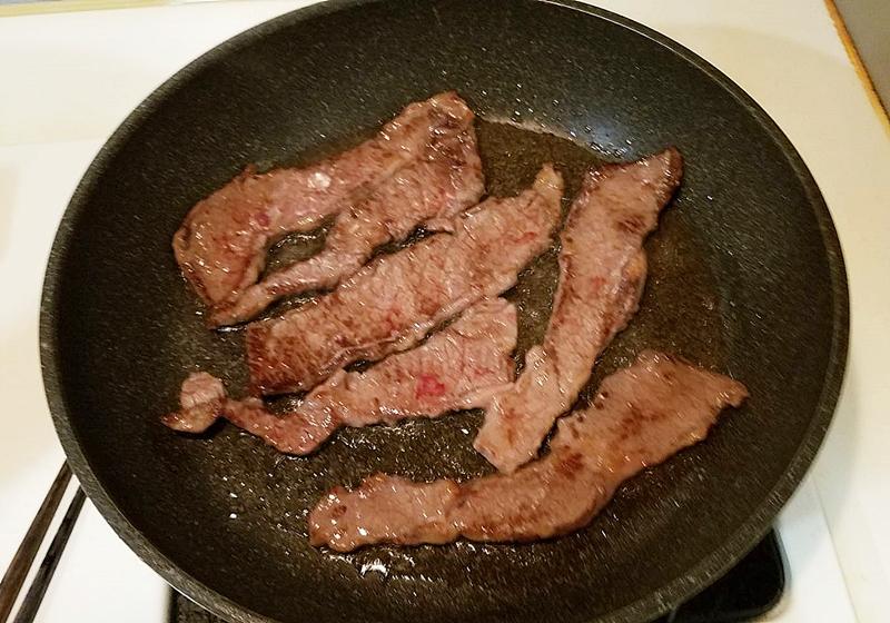 取平底鍋，倒入橄欖油，熱鍋至手離鍋子10公分處可感受到熱度，轉中火，放入牛小排油煎，雙面各煎10-15秒即可取出。
