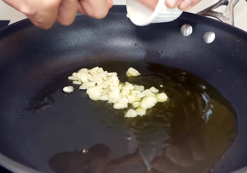 取平底鍋，下足量的橄欖油，蒜片下鍋，中小火煎香，小心不要燒焦或煎上色。