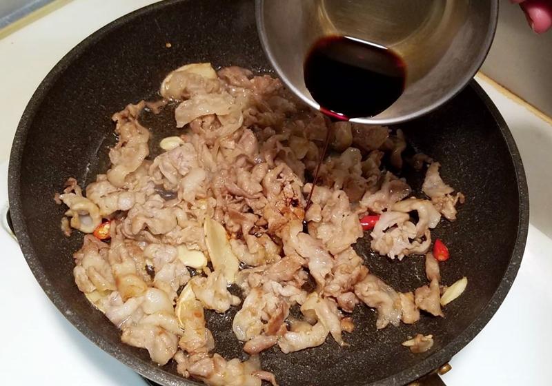 下豬肉片，炒至表面金黃焦香，約七、八分熟時，倒入醬油，中大火燒煮拌勻，使之入味，盛起備用。
