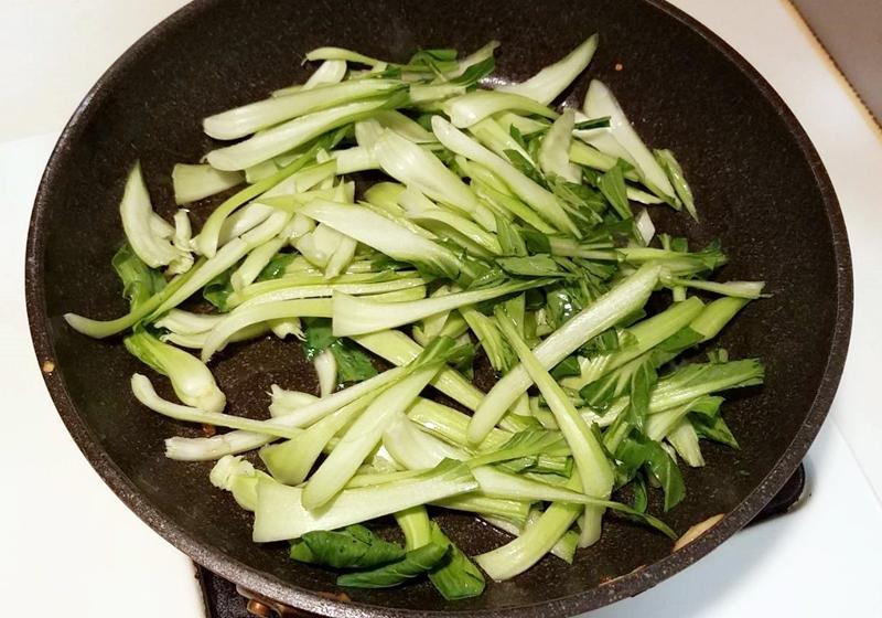 同鍋，下青江菜梗，拌炒至油亮軟化。