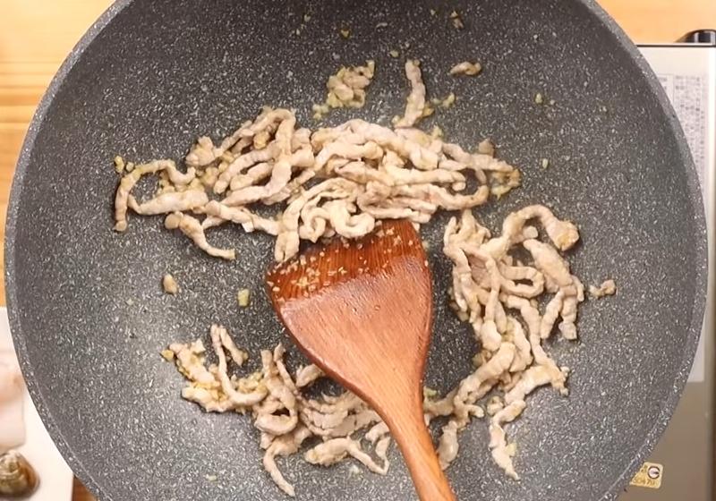 起鍋熱油，放入蒜頭爆香後，下豬肉拌炒至熟成。