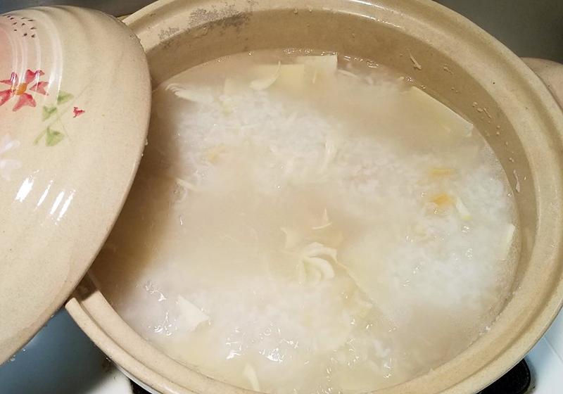 取砂鍋，倒入白飯、冬筍片、薑片、鮑魚罐頭汁、干貝，加水至七分滿，上蓋熬煮約20分鐘。