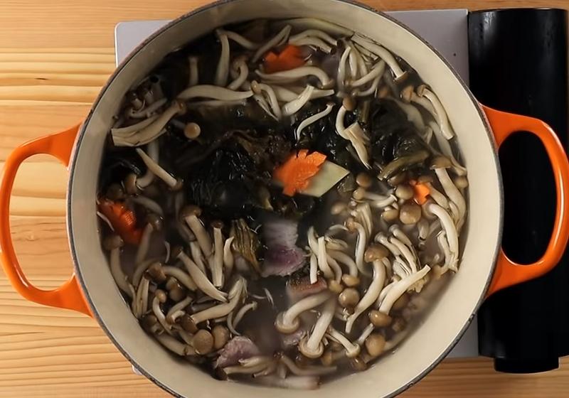 取一鍋，倒入汆燙豬肉的熱水，放入福菜、薑片、紅蘿蔔、五花肉、鴻喜菇。