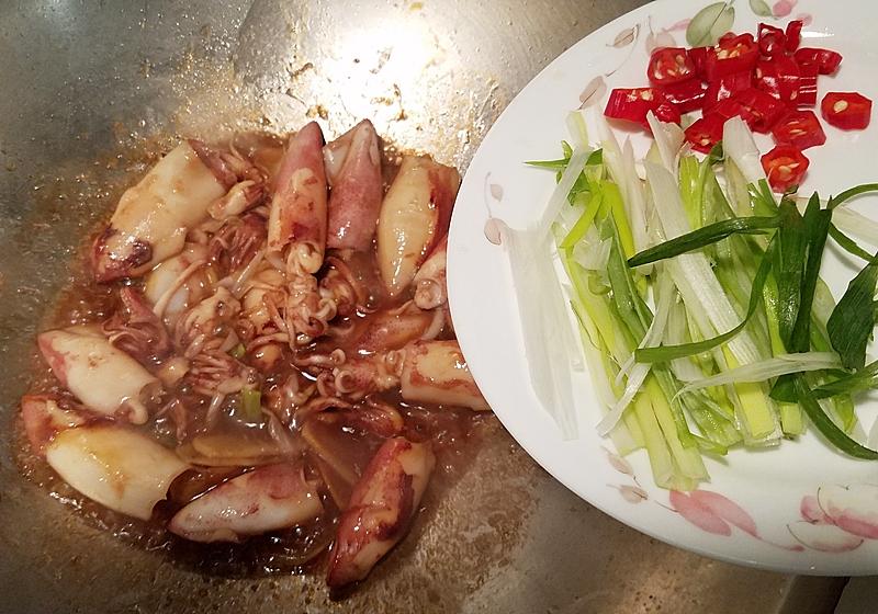 接著下辣椒末、蔥綠絲炒勻，讓配色更好看。