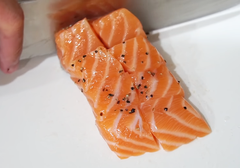 白米洗淨。鮭魚兩面灑上鹽、黑胡椒調味，再切成適口大小。