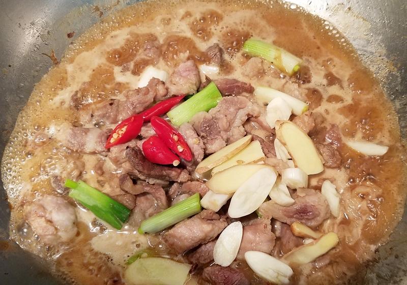 接著加入蔥白、蒜片、薑片、辣椒，小火慢燉25分鐘至豬肉軟透軟嫩。
