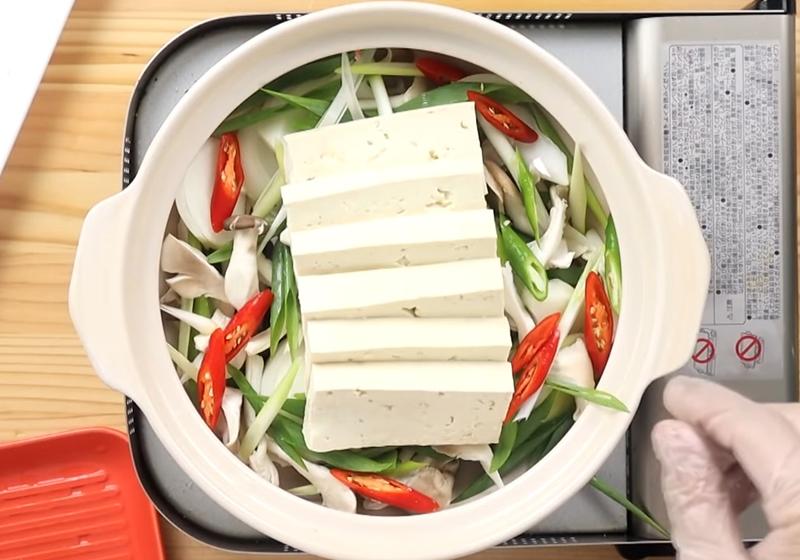 取一鍋，豬肉鋪在最底層，接著放上菇類、青蔥、洋蔥、豆腐、辣椒。