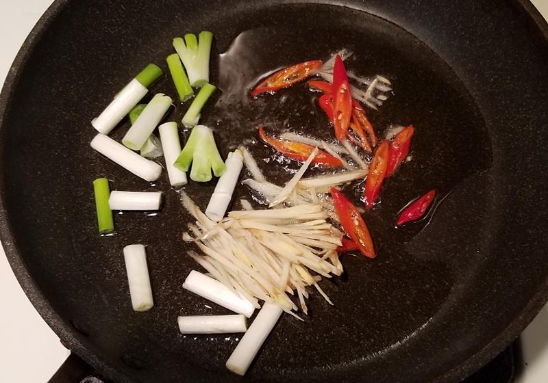 熱油鍋（油放多些），爆香蔥白、辣椒絲、薑絲，煸至蔥白略呈金黃色。