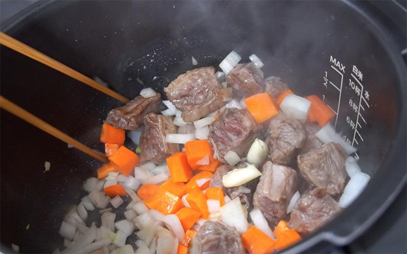 牛肉先下鍋上色焦香，再放入洋蔥、胡蘿蔔與大蒜拌炒。洋蔥轉黃後，再放入大塊的番茄與馬鈴薯一起拌炒。