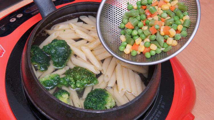 將筆管麵以水鍋加適量鹽煮10分鐘取出，水滾後再將花椰菜與三色蔬菜用小火煮2分鐘，再關火悶煮1分鐘，取出備用。