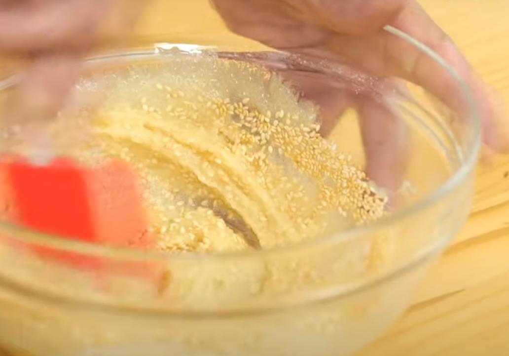 無鹽奶油加熱融化放涼，烤箱事先預熱至180度c。低筋麵粉加入無鹽奶油、砂糖、楓糖漿拌勻後加入白芝麻拌勻完成基本麵糊。