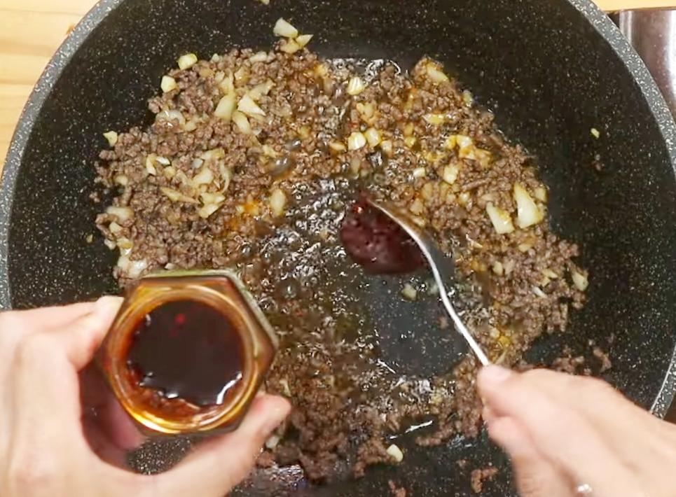 熱鍋,取香辣醬的油入鍋,將牛絞肉炒香,加入洋蔥、蒜仁續炒出香氣,接著放香辣醬拌炒均勻。