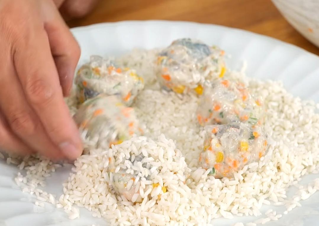 手上沾水，取適量蝦餡揉成小圓球狀（或用湯匙挖取），將蝦球放入糯米盤中，均勻滾動，讓表面裹滿糯米，再於手上輕壓揉圓定型。