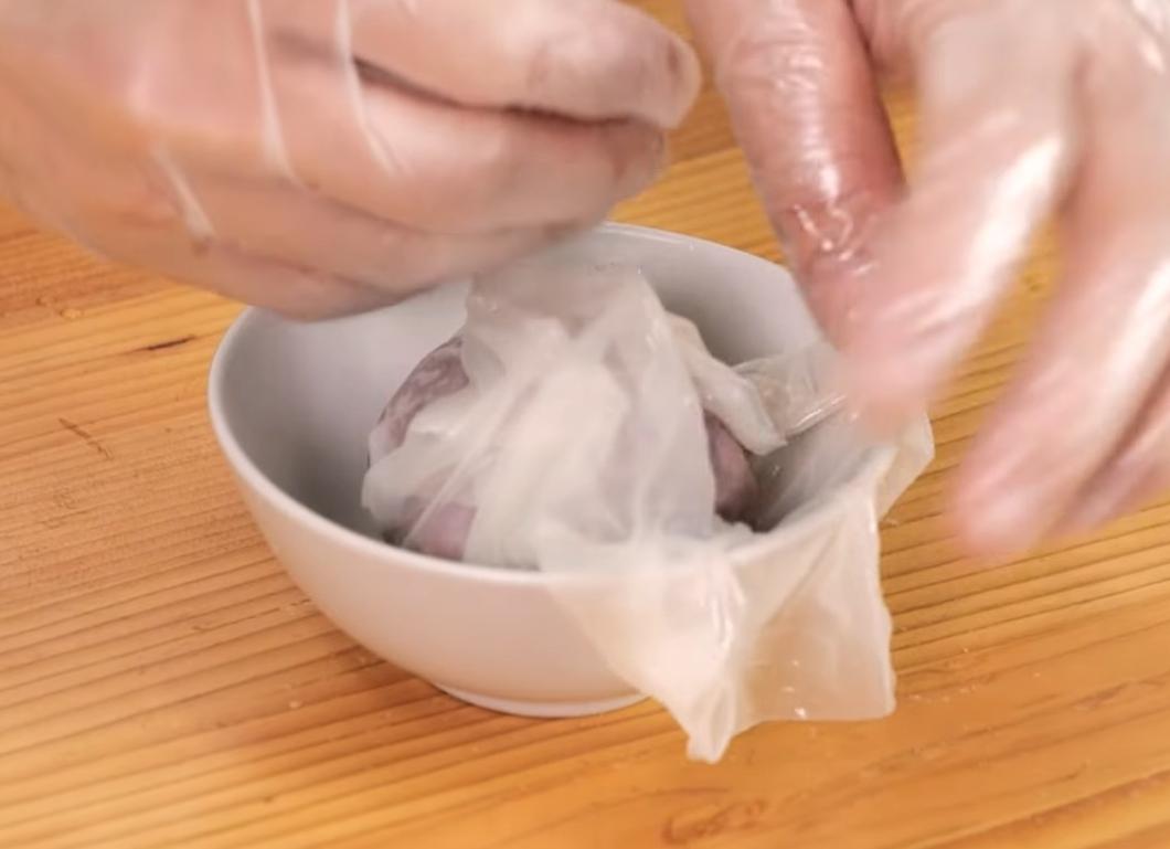 取一張越南春捲皮，泡水軟化後，放在碗中方便包入芋泥球，用剪刀剪去多餘的皮。