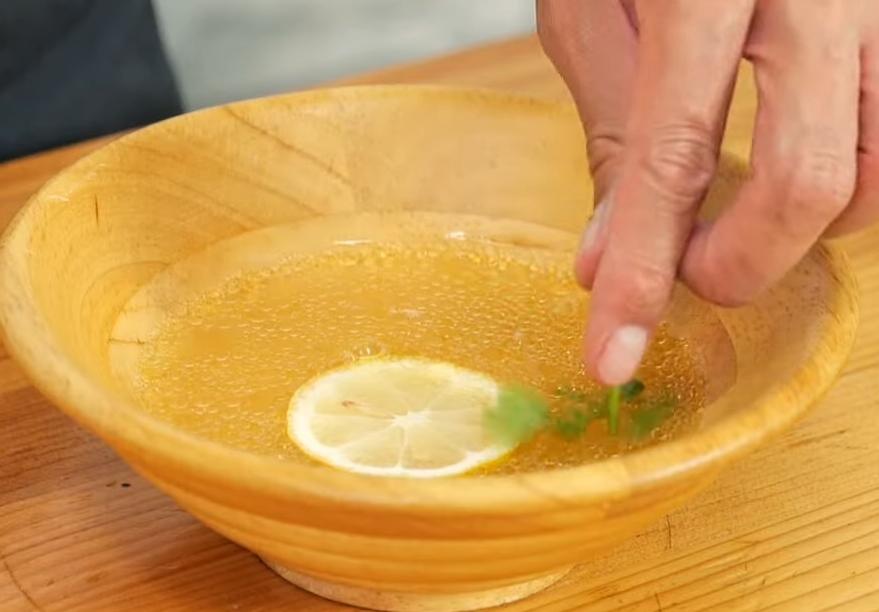 取蒸雞肉流出的湯汁拌入少許鹽巴調味，放入一片檸檬片、少許香菜，即可搭配涼拌手撕雞一起上桌。