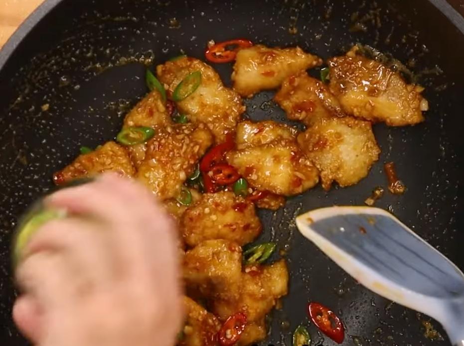 將炸好的魚片放入鍋中輕輕翻炒均勻，起鍋前加入蔥花快速拌勻，上桌放香菜裝飾即完成。