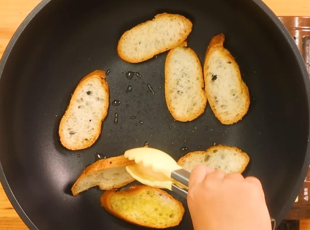 法國麵包淋上橄欖油，放入鍋中兩面煎上色後取出備用。