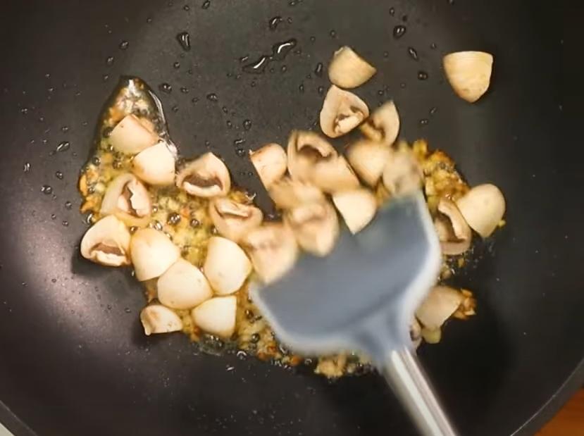 熱鍋倒入初榨橄欖油，放入蒜仁煸炒至金黃，再加入蘑菇跟九層塔拌炒出香氣。