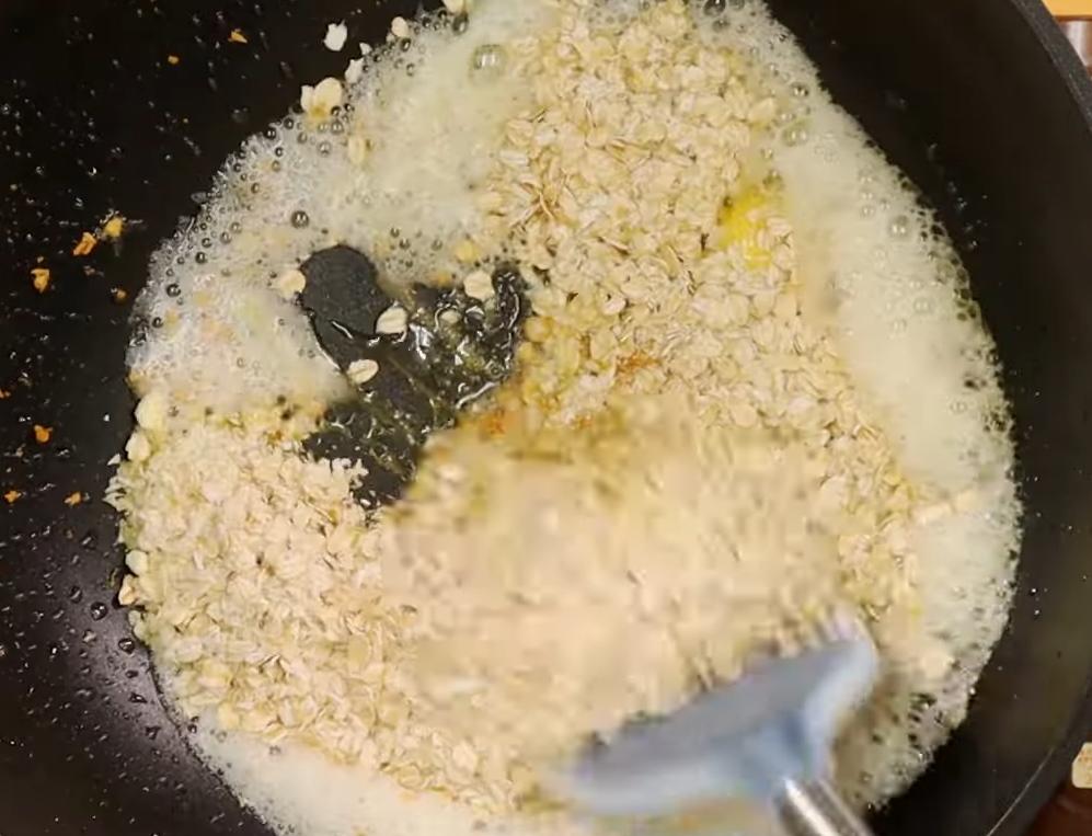 原鍋倒入蒜碎油炸煸至金黃，放入奶油及拌好的麥片粉，快速翻炒至乾鬆酥脆。