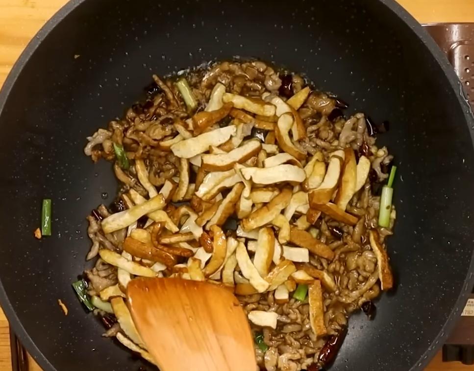 下豆乾絲拌勻，最後下紅辣椒、青辣椒翻炒均勻即可起鍋。