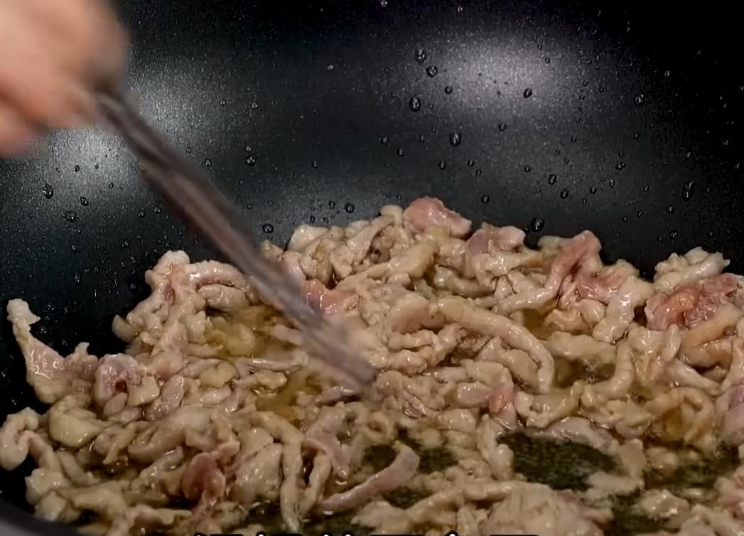 承上鍋，倒回花椒油爆香醃好的肉絲，待九分熟盛出，原鍋原油再加入豆乾絲以大火煎上色後取出備用。