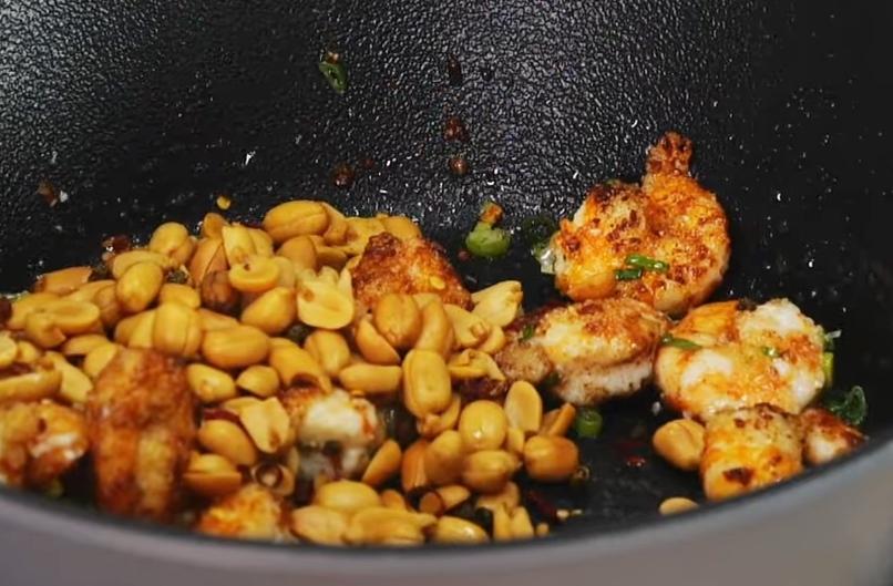 加入蔥花和胡椒鹽拌炒均勻，倒入麻辣花生後關火，用餘溫拌勻後即可盛盤。